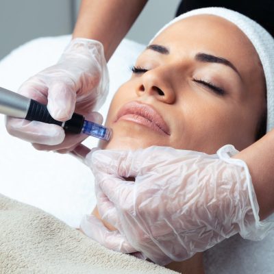 Cosmetologist making mesotherapy injection with dermapen on face for rejuvenation on the spa center.